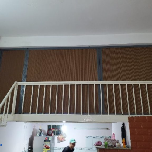 Rèm tổ ong màu nâu khung trắng phía sau lan can gác