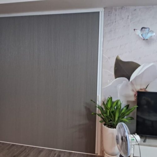 Rèm tổ ong màu xám khung trắng cạnh tường trang trí hoa