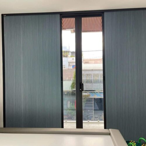 Rèm tổ ong xám khung trắng mở lối giữa cạnh cửa kính