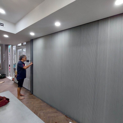 Vách rèm tổ ong màu xám dài với người đứng bên cạnh